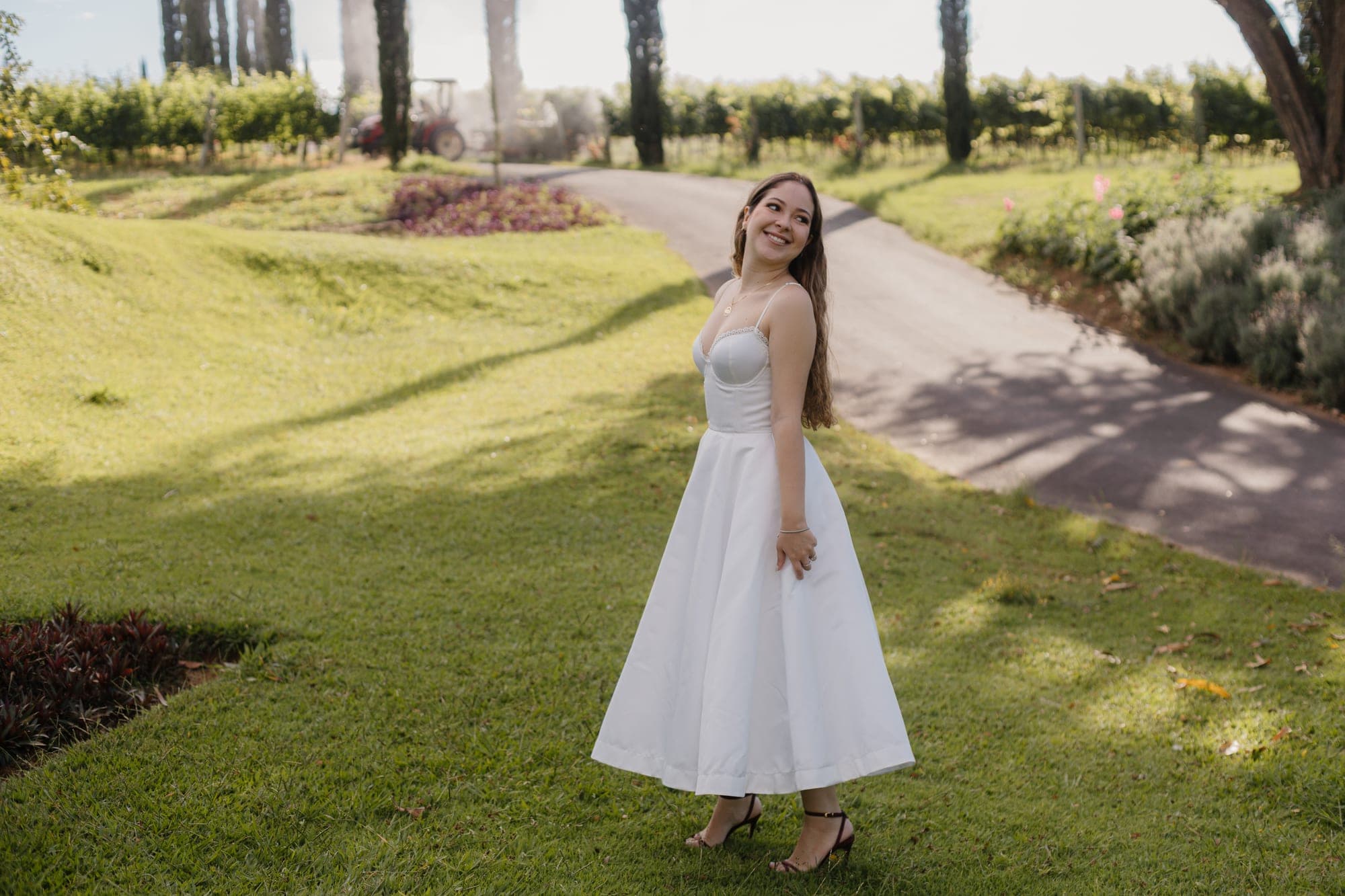 Noiva de vestido branco caminhando pelo gramado