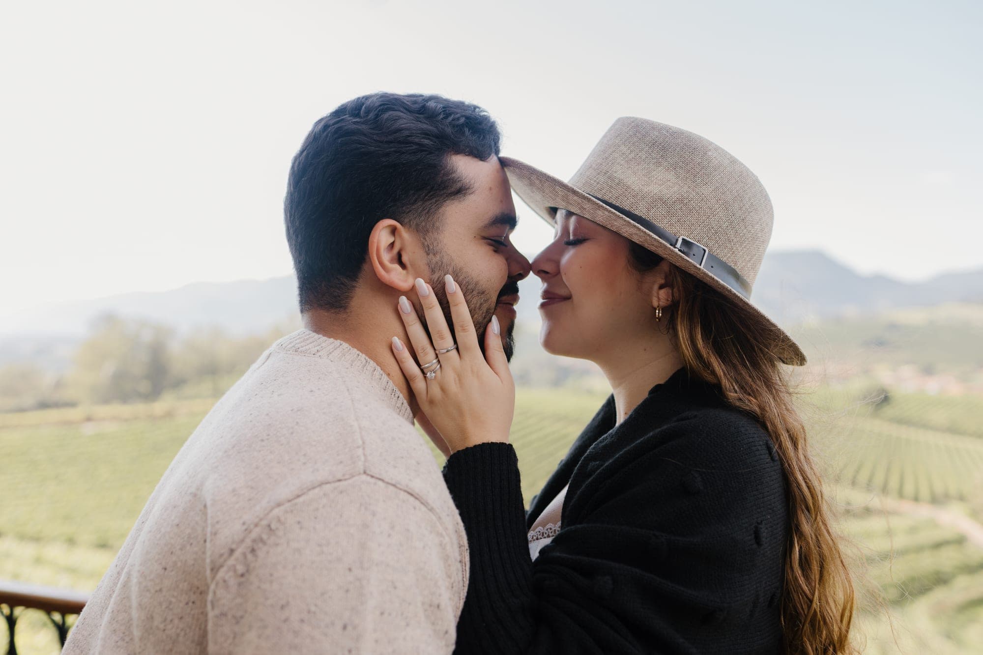 Casal quase se beijando, ela de chapéu