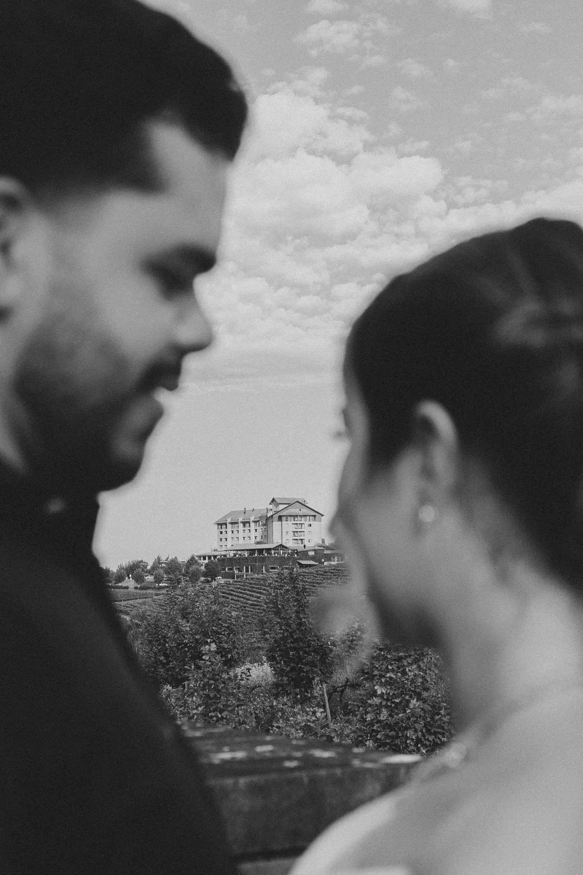 Casal de perfil com o castelo ao fundo, em preto e branco