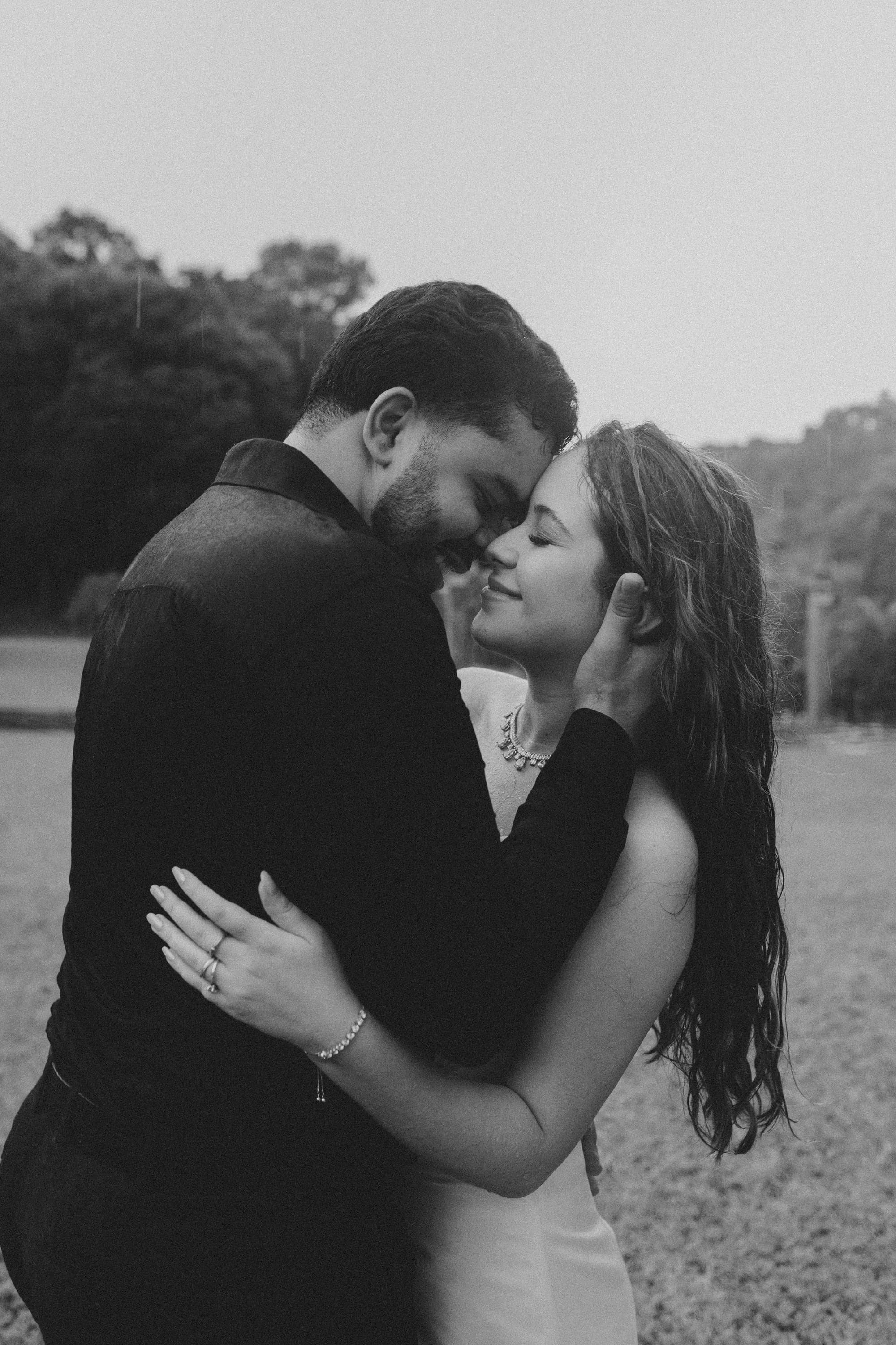 Casal abraçado na chuva, em preto e branco