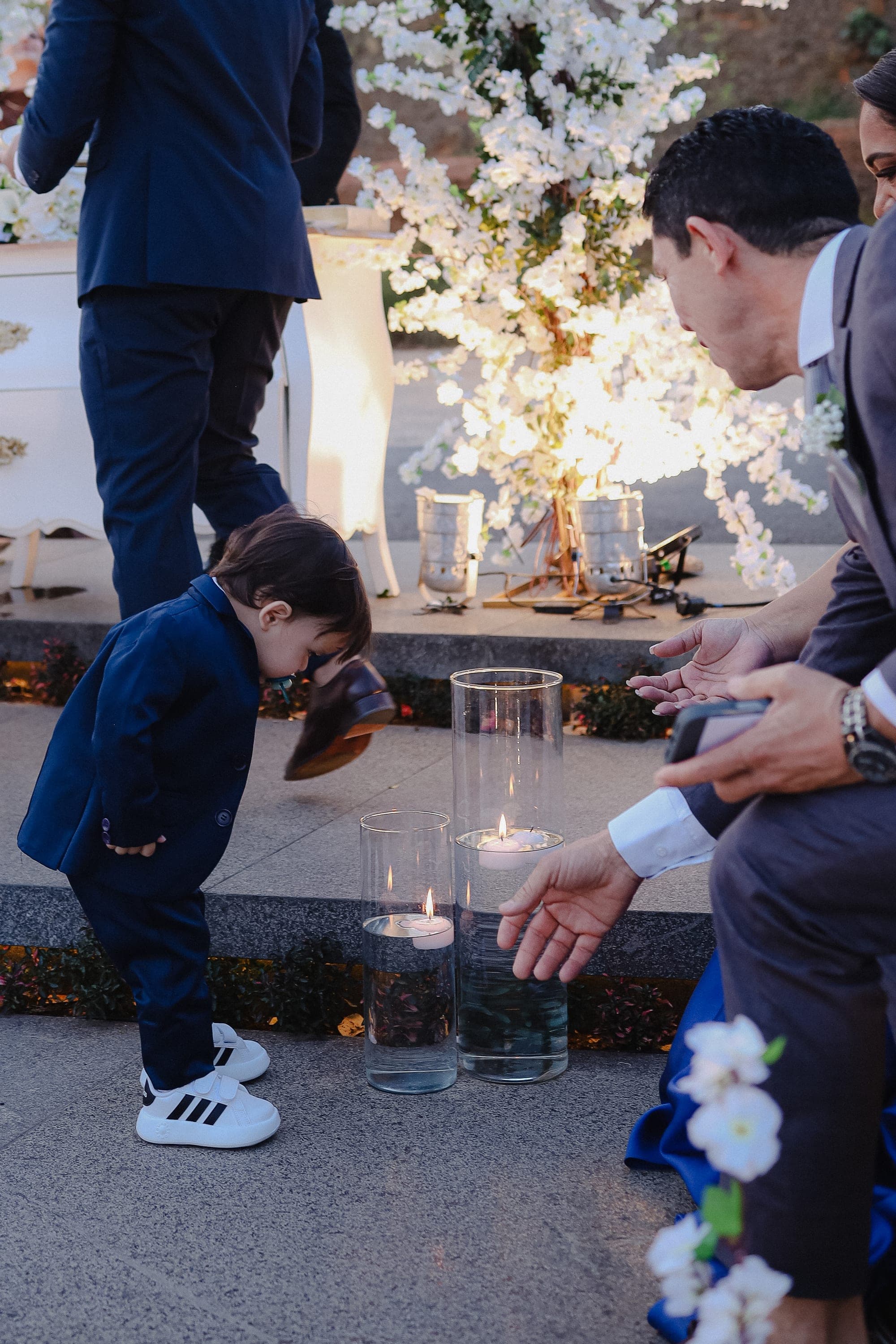 Criança de terno observando as velas antes da entrada