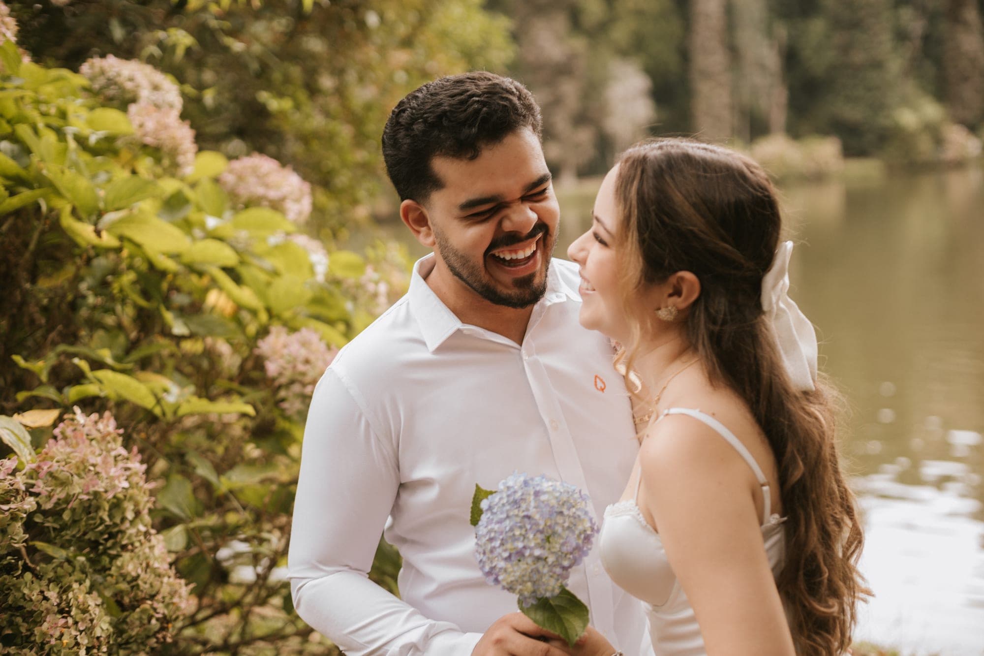 Casal se olhando com hortênsias na mão